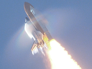 11. STS-106 Mission, Space Shuttle Atlantis, September 8, 2000 at NASA's John F. Kennedy Space Center, State of Florida, USA. Reaching the sound barrier, breaking the sound barrier: Flying at transonic speeds (flying transonically) -- speeds varying near and at the speed of sound (supersonic) -- can generate impressive condensation clouds caused by the Prandtl-Glauert Singularity. For a scientific explanation, see Professor M. S. Cramer's Gallery of Fluid Mechanics, Prandtl-Glauert Singularity at <http://www.GalleryOfFluidMechanics.com/conden/pg_sing.htm>; and Foundations of Fluid Mechanics, Navier-Stokes Equations Potential Flows: Prandtl-Glauert Similarity Laws at <http://www.Navier-Stokes.net/nspfsim.htm>. Photo Credit: Mission: STS-106, Launch of Space Shuttle Atlantis, September 8, 2000, Kennedy Media Gallery (http://mediaarchive.ksc.nasa.gov) Photo Number: KSC-00PP-1416 (http://mediaarchive.ksc.nasa.gov/detail.cfm?mediaid=4720), John F. Kennedy Space Center (KSC, http://www.nasa.gov/centers/kennedy), National Aeronautics and Space Administration (NASA, http://www.nasa.gov), Government of the United States of America. The effect as described by NASA in the photo caption <http://mediaarchive.ksc.nasa.gov/detail.cfm?mediaid=4720>: This view of the shock wave condensation collars backlit by the sun occurred during the launch of Atlantis on STS-106 and was captured on an engineering 35mm motion picture film. One frame was digitized to make this still image. Although the primary effect is created by the Orbiter forward fuselage, secondary effects can be seen on the SRB forward skirt, Orbiter vertical stabilizer and wing trailing edges (behind SSME's).