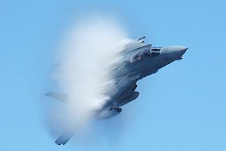 3. United States Navy F-14B Tomcat Fighter Jet. April 26, 2002, Mediterranean Sea. Flying at transonic speeds -- speeds varying near and at the speed of sound (supersonic) -- can generate impressive condensation clouds caused by the Prandtl-Glauert Singularity. For a scientific explanation, see Professor M. S. Cramer's Gallery of Fluid Mechanics, Prandtl-Glauert Singularity at <http://www.GalleryOfFluidMechanics.com/conden/pg_sing.htm>; and Foundations of Fluid Mechanics, Navier-Stokes Equations Potential Flows: Prandtl-Glauert Similarity Laws at <http://www.Navier-Stokes.net/nspfsim.htm>. Photo Credit: Photographer's Mate 3rd Class Ramon Preciado, Navy NewsStand - Eye on the Fleet Photo Gallery (http://www.news.navy.mil/view_photos.asp, 020426-N-8029P-001), United States Navy (USN, http://www.navy.mil), United States Department of Defense (DoD, http://www.DefenseLink.mil or http://www.dod.gov), Government of the United States of America (USA).
