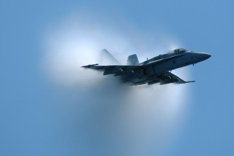 4. An F/A-18 Hornet Fighter Jet, June 9, 2004. United States Navy, Atlantic Ocean. Reaching the sound barrier, breaking the sound barrier: Flying at transonic speeds (flying transonically) -- speeds varying near and at the speed of sound (supersonic) -- can generate impressive condensation clouds caused by the Prandtl-Glauert Singularity. For a scientific explanation, see Professor M. S. Cramer's Gallery of Fluid Mechanics, Prandtl-Glauert Singularity at <http://www.GalleryOfFluidMechanics.com/conden/pg_sing.htm>; and Foundations of Fluid Mechanics, Navier-Stokes Equations Potential Flows: Prandtl-Glauert Similarity Laws at <http://www.Navier-Stokes.net/nspfsim.htm>. Photo Credit: Photographer's Mate 3rd Class Milosz Reterski, Navy NewsStand - Eye on the Fleet Photo Gallery (http://www.news.navy.mil/view_photos.asp, 040609-N-9742R-041), United States Navy (USN, http://www.navy.mil), United States Department of Defense (DoD, http://www.DefenseLink.mil or http://www.dod.gov), Government of the United States of America (USA).