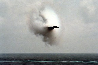 5. An F-14A Tomcat Fighter Jet, January 31, 1987, United States Navy. Reaching the sound barrier, breaking the sound barrier: Flying at transonic speeds (flying transonically) -- speeds varying near and at the speed of sound (supersonic) -- can generate impressive condensation clouds caused by the Prandtl-Glauert Singularity. For a scientific explanation, see Professor M. S. Cramer's Gallery of Fluid Mechanics, Prandtl-Glauert Singularity at <http://www.GalleryOfFluidMechanics.com/conden/pg_sing.htm>; and Foundations of Fluid Mechanics, Navier-Stokes Equations Potential Flows: Prandtl-Glauert Similarity Laws at <http://www.Navier-Stokes.net/nspfsim.htm>. Photo Credit: Photographer's Mate 2nd Class Johnson, United States Navy; Defense Visual Information (DVI, http://www.DefenseImagery.mil, DN-SC-87-11321 and DNSC8711321) and United States Navy (USN, http://www.navy.mil), United States Department of Defense (DoD, http://www.DefenseLink.mil or http://www.dod.gov), Government of the United States of America (USA).