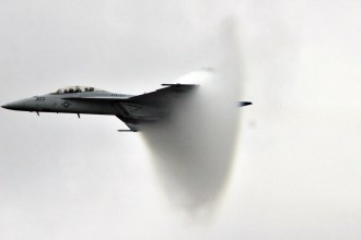 9. An F/A-18F Super Hornet Fighter Jet, November 13, 2004, United States Navy. Pensacola, State of Florida, USA. Reaching the sound barrier, breaking the sound barrier: Flying at transonic speeds (flying transonically) -- speeds varying near and at the speed of sound (supersonic) -- can generate impressive condensation clouds caused by the Prandtl-Glauert Singularity. For a scientific explanation, see Professor M. S. Cramer's Gallery of Fluid Mechanics, Prandtl-Glauert Singularity at <http://www.GalleryOfFluidMechanics.com/conden/pg_sing.htm>; and Foundations of Fluid Mechanics, Navier-Stokes Equations Potential Flows: Prandtl-Glauert Similarity Laws at <http://www.Navier-Stokes.net/nspfsim.htm>. Photo Credit: Photographer's Mate 2nd Class Mark A. Ebert, Navy NewsStand - Eye on the Fleet Photo Gallery (http://www.news.navy.mil/view_photos.asp, 041113-N-4204E-512), United States Navy (USN, http://www.navy.mil), United States Department of Defense (DoD, http://www.DefenseLink.mil or http://www.dod.gov), Government of the United States of America (USA).