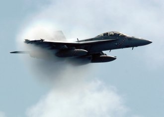11. An F/A-18F Super Hornet Fighter Assigned to the 'Diamondbacks' of Strike Fighter Squadron One Zero Two (VFA-102). July 27, 2005, USS Kitty Hawk (CV 63), United States Navy in the Philippine Sea. Reaching the sound barrier, breaking the sound barrier: Flying at transonic speeds (flying transonically) -- speeds varying near and at the speed of sound (supersonic) -- can generate impressive condensation clouds caused by the Prandtl-Glauert Singularity. For a scientific explanation, see Professor M. S. Cramer's Gallery of Fluid Mechanics, Prandtl-Glauert Singularity at <http://www.GalleryOfFluidMechanics.com/conden/pg_sing.htm>; and Foundations of Fluid Mechanics, Navier-Stokes Equations Potential Flows: Prandtl-Glauert Similarity Laws at <http://www.Navier-Stokes.net/nspfsim.htm>. Photo Credit: Photographer's Mate 3rd Class Jonathan Chandler, Navy NewsStand - Eye on the Fleet Photo Gallery (http://www.news.navy.mil/view_photos.asp, 050727-N-3488C-047), United States Navy (USN, http://www.navy.mil), United States Department of Defense (DoD, http://www.DefenseLink.mil or http://www.dod.gov), Government of the United States of America (USA).