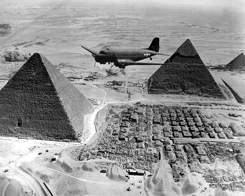 10. An Air Transport Command Plane Flies Over The Pyramids During World War II (WWII), 1943, Jumhuriyat Misr al-Arabiyah - Arab Republic of Egypt. Photo Credit: Defense Visual Information Center (DVIC, http://www.DoDMedia.osd.mil, HD-SN-99-02674, NARA File #: 111-SC-179564), United States Department of Defense (DoD, http://www.DefenseLink.mil or http://www.dod.gov), Government of the United States of America (USA).