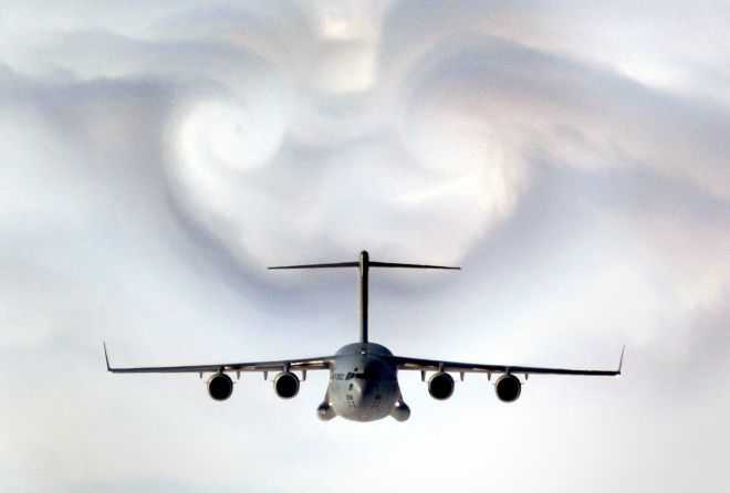 The United States Air Force C-17 Globemaster III Military Transport Parts the Western South Carolina Clouds Causing an Impressive Corridor-in-the-Clouds and Cloud Formations, February 2, 2003. State of South Carolina, USA. Photo Credit: Staff Sgt. D. Myles Cullen, 1st Combat Camera Squadron, Air Force Link - Photos (http://www.af.mil/photos, 030202-F-0193C-004, Parting clouds), United States Air Force (USAF, http://www.af.mil), United States Department of Defense (DoD, http://www.DefenseLink.mil or http://www.dod.gov), Government of the United States of America (USA). C-17 Globemaster III fact sheets from the United States Air Force <http://www.af.mil/factsheets/factsheet.asp?fsID=86> and The Boeing Company <http://www.boeing.com/defense-space/military/c17/sitemap.html>.