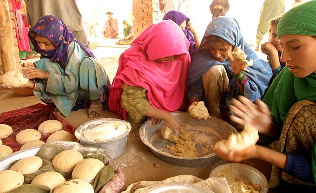 1. Dressed in Colorful Attire, Afghan Ladies Mix, Press, and Shape Wheat Bread Dough for Makeshift Bakeries in Refugee Camps Near the Afghanistan/Pakistan Border, November 15, 2001. Dowlat-e Eslami-ye Afghanestan - Transitional Islamic State of Afghanistan. Photo Credit: Martin Lueders, USAID Humanitarian Crisis in Central Asia - Photos from the Field (http://www.usaid.gov/press/releases/2001/images/centralasia.html), United States Agency for International Development (USAID, http://www.usaid.gov), Government of the United States of America (USA).