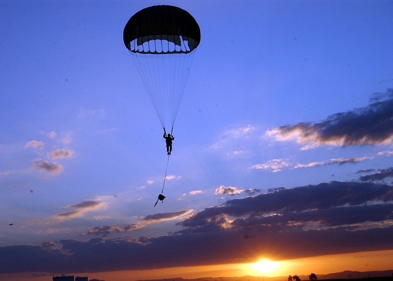 Photo #2. With the Parachute Fully Deployed, a Parachuter With Explosive Ordnance Mobile Unit Eight (EODMU-8) Floats Down to Earth Out of the Blue Sky at Sunrise or Sunset, August 28, 2006. Sigonella, Sicily, Repubblica Italiana - Italian Republic (Italy). Photo Credit: Mass Communication Specialist Seaman Chad Zenthoefer, Navy NewsStand - Eye on the Fleet Photo Gallery (http://www.news.navy.mil/view_photos.asp, 060828-N-3572Z-025), United States Navy (USN, http://www.navy.mil), United States Department of Defense (DoD, http://www.DefenseLink.mil or http://www.dod.gov), Government of the United States of America (USA).