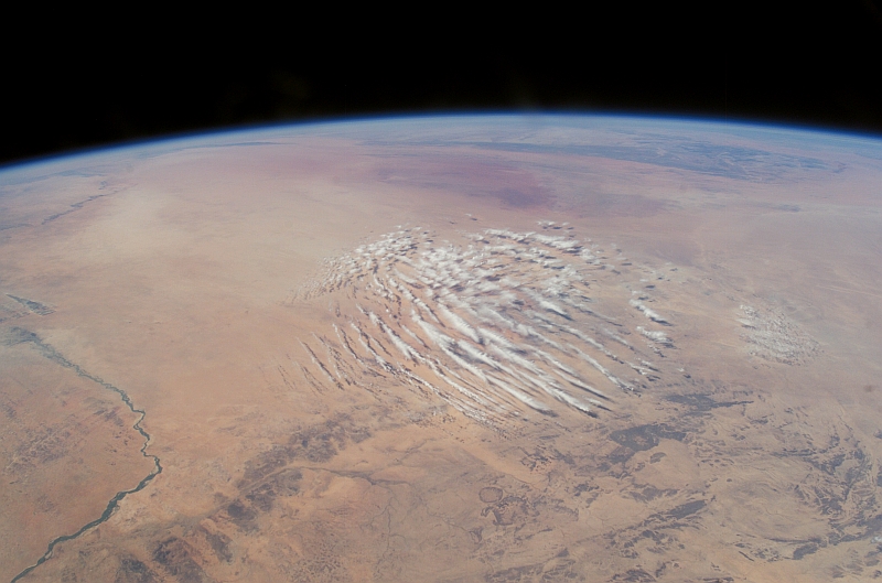 29. Cloud Pattern Over the Sahara, January 3, 2003 at 12:27:46.695 GMT, Republique du Mali - Republic of Mali, As Seen From the International Space Station (Expedition 6), Latitude (LAT): 17.3, Longitude (LON): 3.6, Altitude (ALT): 212 Nautical Miles, Sun Azimuth (AZI): 193 degrees, Sun Elevation Angle (ELEV): 49 degrees. Photo Credit: NASA; ISS006-E-14527, Earth's Atmospheric limb, Cloud pattern, Sahara Desert, Niger River, Mali, International Space Station (Expedition Six); Image Science and Analysis Laboratory, NASA-Johnson Space Center. 'Astronaut Photography of Earth - Display Record.' <http://eol.jsc.nasa.gov/scripts/sseop/photo.pl?mission=ISS006&roll=E&frame=14527>; National Aeronautics and Space Administration (NASA, http://www.nasa.gov), Government of the United States of America (USA).