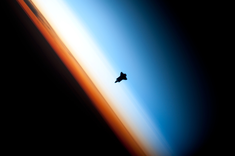 35. Orbital Sunset: A Beautiful View of Earth's Colorful Horizon and the Silhouette of Space Shuttle Endeavour (STS-130), February 9, 2010, As Seen From the International Space Station (Expedition Twenty-Two) While Orbiting Above the South Pacific Ocean Off the Coast of Southern Chile, South America: Latitude (LAT): -46.9, Longitude (LON): -80.5, Altitude (ALT): 183 Nautical Miles. Photo Credit: STS-130 Shuttle Mission Imagery (http://spaceflight.nasa.gov/gallery/images/shuttle/sts-130/ndxpage1.html), ISS022-E-062672 (http://spaceflight.nasa.gov/gallery/images/shuttle/sts-130/html/iss022e062672.html), NASA Human Space Flight (http://spaceflight.nasa.gov), National Aeronautics and Space Administration (NASA, http://www.nasa.gov), Government of the United States of America. Additional details provided by NASA: 'The orange layer is the troposphere, where all of the weather and clouds which we typically watch and experience are generated and contained. This orange layer gives way to the whitish Stratosphere and then into the Mesosphere. In some frames the black color is part of a window frame rather than the blackness of space.'