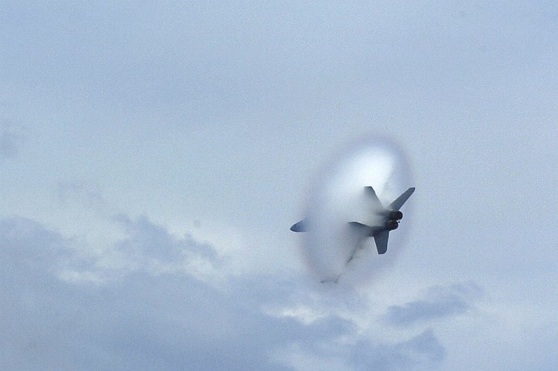 5. An F/A-18F Super Hornet Fighter Jet Assigned to Strike Fighter Squadron One Zero Two (VFA-102), Carrier Air Wing Five (CVW-5), USS Kitty Hawk (CV 63), United States Navy, September 11, 2006, East China Sea. Flying at transonic speeds (flying transonically) -- speeds varying near and at the speed of sound (supersonic) -- can generate impressive condensation clouds caused by the Prandtl-Glauert Singularity. For a scientific explanation, see Professor M. S. Cramer's Gallery of Fluid Mechanics, Prandtl-Glauert Singularity at <http://www.GalleryOfFluidMechanics.com/conden/pg_sing.htm>; and Foundations of Fluid Mechanics, Navier-Stokes Equations Potential Flows: Prandtl-Glauert Similarity Laws at <http://www.Navier-Stokes.net/nspfsim.htm>. Photo Credit: Mass Communication Specialist Seaman Joshua Wayne LeGrand, Navy NewsStand - Eye on the Fleet Photo Gallery (http://www.news.navy.mil/view_photos.asp, 060911-N-8604L-741), United States Navy (USN, http://www.navy.mil), United States Department of Defense (DoD, http://www.DefenseLink.mil or http://www.dod.gov), Government of the United States of America (USA).