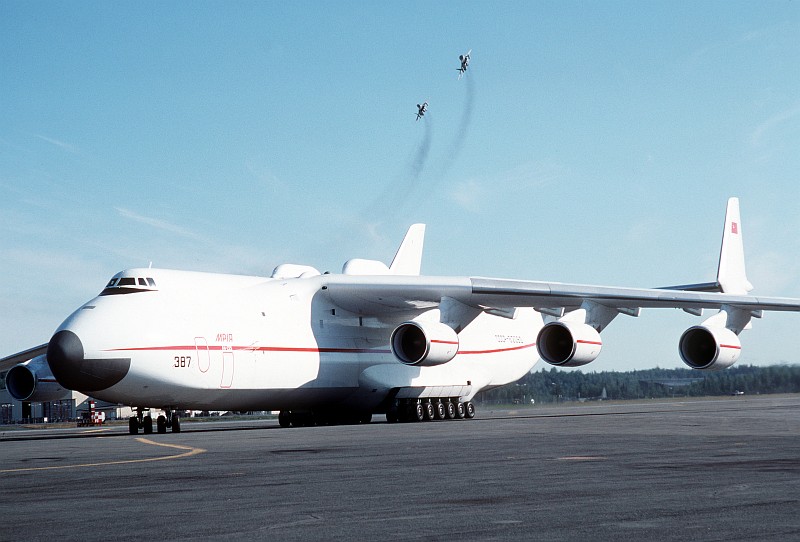 3. A Soviet An-225 Mriya Heavy Transport Aircraft Parked On the Flight Line As Two Fighter Jets Fly Overhead, August 1989, Elmendorf Air Force Base, State of Alaska, USA. Photo Credit: SSgt. Kevin L. Bishop, United States Air Force (USAF, http://www.af.mil); Defense Visual Information Center (DVIC, http://www.DoDMedia.osd.mil, DFST9005764) and United States Air Force (USAF, http://www.af.mil), United States Department of Defense (DoD, http://www.DefenseLink.mil or http://www.dod.gov), Government of the United States of America (USA).