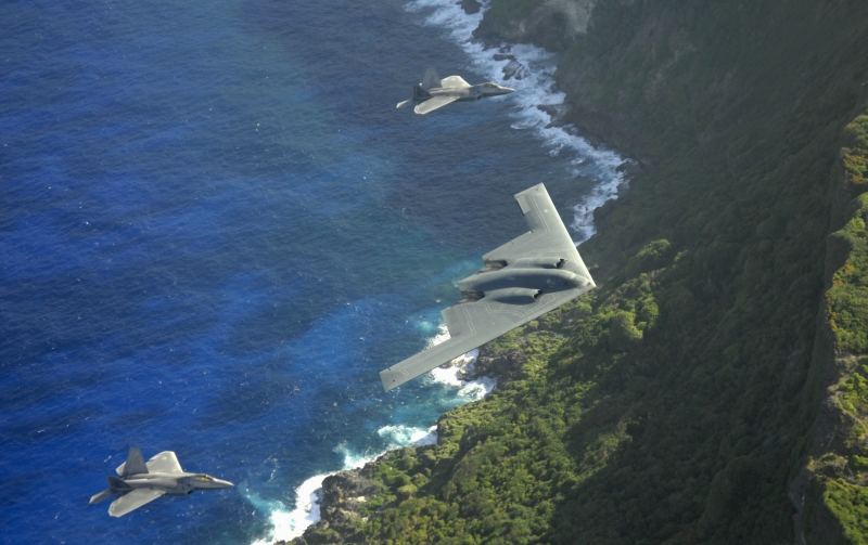 2. The B-2 Spirit and Two F-22A Raptors Fly In Formation Above As Waves From the Pacific Ocean Crash On the Rocks Below, April 7, 2009, Territory of Guam, USA. Photo Credit: Master Sgt. Kevin J. Gruenwald, United States Air Force; Defense Visual Information (DVI, http://www.DefenseImagery.mil, 090414-F-6911G-001) and United States Air Force (USAF, http://www.af.mil), United States Department of Defense (DoD, http://www.DefenseLink.mil or http://www.dod.gov), Government of the United States of America (USA).