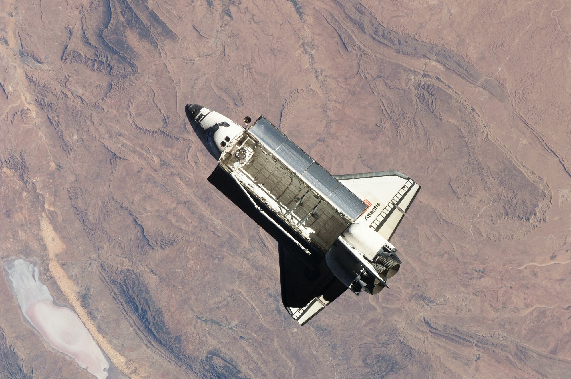 1. Space Shuttle Atlantis (STS-129) high above rugged terrain, 25 November 2009