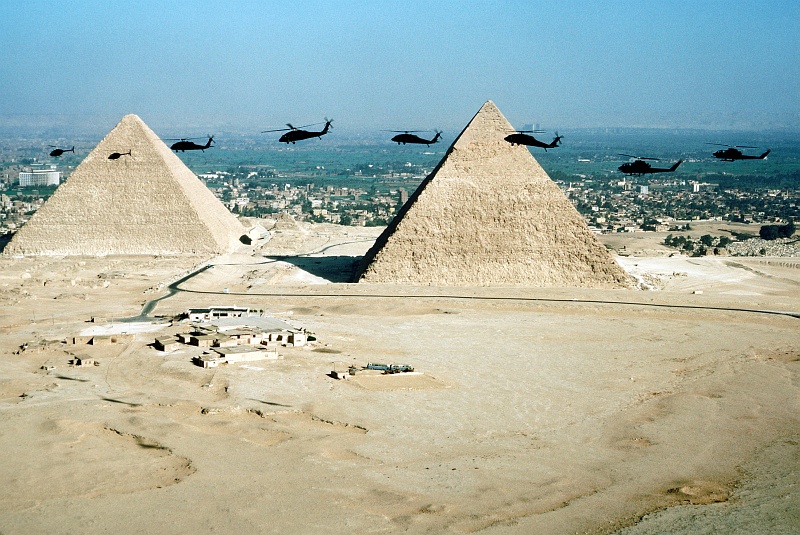 7. Aerial Front-View of West Cairo, Two of The Great Pyramids and, Participating in Exercise Bright Star '80 (From Left-to-Right) 'Two OH-58 Kiowa Helicopters, Four UH-60 Black Hawk Helicopters and Two AH-1 Cobra Helicopters', November 9, 1980, Jumhuriyat Misr al-Arabiyah - Arab Republic of Egypt. Photo Credit: Staff Sgt. Bill Thompson; Defense Visual Information Center (DVIC, http://www.DoDMedia.osd.mil, DF-ST-82-06256), United States Department of Defense (DoD, http://www.DefenseLink.mil or http://www.dod.gov), Government of the United States of America (USA).