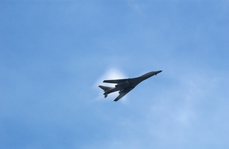 6. A B-1B Lancer Bomber Creating a Prandtl-Glauert Condensation Cloud, United States Air Force. January 16, 2004, Southwest Asia. USAF image ID number: 040116-F-0971G-148. Flying at transonic speeds -- speeds varying near and at the speed of sound (supersonic) -- can generate impressive condensation clouds caused by the Prandtl-Glauert Singularity. For a scientific explanation, see Dr. Mark. S. Cramer's Gallery of Fluid Mechanics, Prandtl-Glauert Singularity at <http://www.GalleryOfFluidMechanics.com/conden/pg_sing.htm>; the Prandtl-Glauert Condensation Clouds tutorial at <http://FluidMech.net/tutorials/sonic/prandtl-glauert-clouds.htm>; and Foundations of Fluid Mechanics, Navier-Stokes Equations Potential Flows: Prandtl-Glauert Similarity Laws at <http://www.Navier-Stokes.net/nspfsim.htm>. Photo Credit: Staff Sgt. Shelley Gill, Still Photography Journeyman, 125th Fighter Wing, Florida Air National Guard, USA; 040116-F-0971G-148, United States Air Force (USAF, http://www.af.mil), United States Department of Defense (DoD, http://www.DefenseLink.mil or http://www.dod.gov), Government of the United States of America (USA).