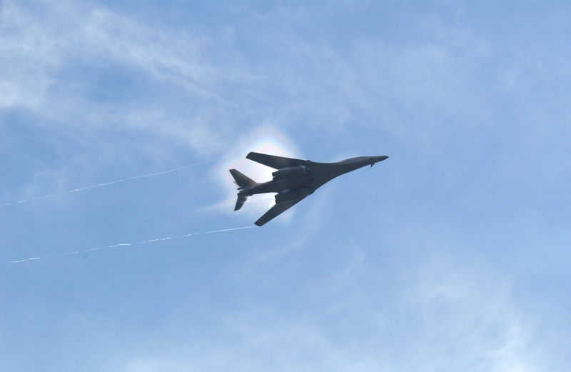 7. A B-1B Lancer Bomber Creating a Prandtl-Glauert Condensation Cloud, United States Air Force. January 16, 2004, Southwest Asia. USAF image ID number: 040116-F-0971G-150. Flying at transonic speeds -- speeds varying near and at the speed of sound (supersonic) -- can generate impressive condensation clouds caused by the Prandtl-Glauert Singularity. For a scientific explanation, see Dr. Mark. S. Cramer's Gallery of Fluid Mechanics, Prandtl-Glauert Singularity at <http://www.GalleryOfFluidMechanics.com/conden/pg_sing.htm>; the Prandtl-Glauert Condensation Clouds tutorial at <http://FluidMech.net/tutorials/sonic/prandtl-glauert-clouds.htm>; and Foundations of Fluid Mechanics, Navier-Stokes Equations Potential Flows: Prandtl-Glauert Similarity Laws at <http://www.Navier-Stokes.net/nspfsim.htm>. Photo Credit: Staff Sgt. Shelley Gill, Still Photography Journeyman, 125th Fighter Wing, Florida Air National Guard, USA; 040116-F-0971G-150, United States Air Force (USAF, http://www.af.mil), United States Department of Defense (DoD, http://www.DefenseLink.mil or http://www.dod.gov), Government of the United States of America (USA).