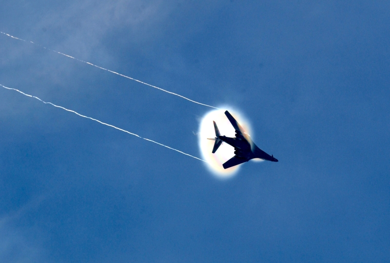 12. A B-1B Lancer Bomber Creating a Prandtl-Glauert Condensation Cloud, United States Air Force. January 16, 2004, Southwest Asia. USAF image ID number: 040116-F-0971G-156. Flying at transonic speeds -- speeds varying near and at the speed of sound (supersonic) -- can generate impressive condensation clouds caused by the Prandtl-Glauert Singularity. For a scientific explanation, see Dr. Mark. S. Cramer's Gallery of Fluid Mechanics, Prandtl-Glauert Singularity at <http://www.GalleryOfFluidMechanics.com/conden/pg_sing.htm>; the Prandtl-Glauert Condensation Clouds tutorial at <http://FluidMech.net/tutorials/sonic/prandtl-glauert-clouds.htm>; and Foundations of Fluid Mechanics, Navier-Stokes Equations Potential Flows: Prandtl-Glauert Similarity Laws at <http://www.Navier-Stokes.net/nspfsim.htm>. Photo Credit: Staff Sgt. Shelley Gill, Still Photography Journeyman, 125th Fighter Wing, Florida Air National Guard, USA; 040116-F-0971G-156, United States Air Force (USAF, http://www.af.mil), United States Department of Defense (DoD, http://www.DefenseLink.mil or http://www.dod.gov), Government of the United States of America (USA).