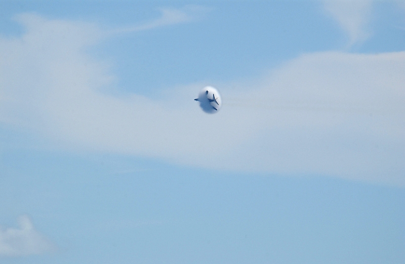 2. Another View of the Same USAF B-1B Lancer Bomber With Its Prandtl-Glauert Cloud. Large white clouds are already present as the United States Air Force B-1B Lancer bomber flies transonically -- speeds varying near and at the speed of sound (supersonic) -- through the blue Southwest Asia sky on January 16, 2004. At these speeds an impressive cloud may suddenly appear around the aircraft. And as shown in these sequential photographs, all the right factors were present to form one. This type of vapor cloud is a called a Prandtl-Glauert condensation cloud and is caused by the Prandtl-Glauert singularity. In the ChamorroBible.org 3rd Collection of Prandtl-Glauert Condensation Clouds presented Umayanggan (Disiembre) 16, 2004 is a photo sequence of the same B-1B Lancer showing the sequential development of a different Prandtl-Glauert (P-G) cloud. For a scientific explanation, see Dr. Mark. S. Cramer's Gallery of Fluid Mechanics, Prandtl-Glauert Singularity at <http://www.GalleryOfFluidMechanics.com/conden/pg_sing.htm>; the Prandtl-Glauert Condensation Clouds tutorial at <http://FluidMech.net/tutorials/sonic/prandtl-glauert-clouds.htm>; and Foundations of Fluid Mechanics, Navier-Stokes Equations Potential Flows: Prandtl-Glauert Similarity Laws at <http://www.Navier-Stokes.net/nspfsim.htm>. Photo Credit: Staff Sgt. Shelley R. Gill, Still Photography Journeyman, 125th Fighter Wing, Florida Air National Guard, USA; United States Air Force (USAF, http://www.af.mil), United States Department of Defense (DoD, http://www.DefenseLink.mil or http://www.dod.gov), Government of the United States of America (USA). USAF image ID number: 040116-F-0971G-130.