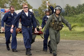 Carrying a Tsunami Victim to a Triage Site Located on Sultan Iskandar Muda Air Force Base, January 8, 2005. Banda Aceh, Sumatra, Republik Indonesia. Photo Credit: Photographer's Mate 3rd Class Katrina V. Walter, Navy NewsStand - Eye on the Fleet Photo Gallery (http://www.news.navy.mil/view_photos.asp, 050108-N-6736W-012), United States Navy (USN, http://www.navy.mil), United States Department of Defense (DoD, http://www.DefenseLink.mil or http://www.dod.gov), Government of the United States of America (USA). This photograph is included in ChamorroBible.org: The Great Earthquake and Catastrophic Tsunami of 2004, Part 4.