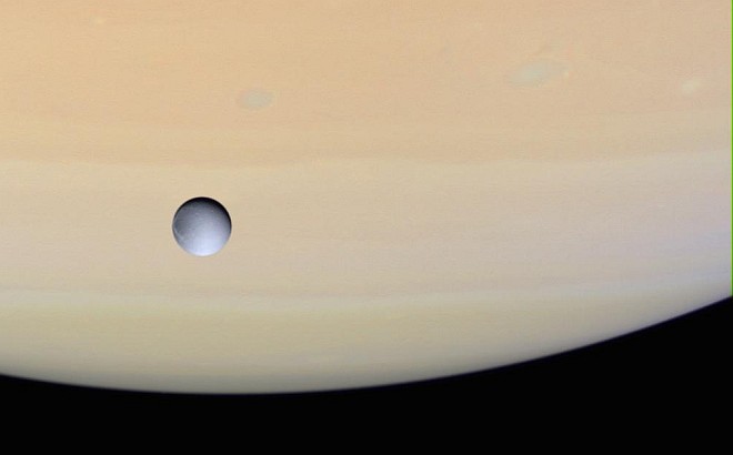 Saturn and Icy Dione, One of the Planet's Many Moons. Photo Credit: Cassini-Huygens Mission (http://saturn.jpl.nasa.gov), Cassini Orbiter, December 14, 2004; Planetary Photojournal (http://photojournal.jpl.nasa.gov, PIA06155), National Aeronautics and Space Administration (NASA, http://www.nasa.gov)/Jet Propulsion Laboratory (JPL, http://www.jpl.nasa.gov)/Space Science Institute (http://ciclops.org), Government of the United States of America.