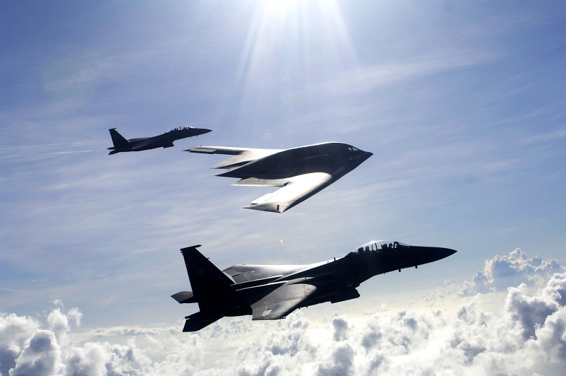 17. A U.S. Air Force (USAF) B-2 Spirit Stealth Bomber and Two USAF F-15E Strike Eagle Fighter Jets Fly High Above the Clouds Over the Pacific Ocean, July 7, 2005, Andersen Air Force Base, Territory of Guam, USA. Photo Credit: Tech. Sgt. Cecilio Ricardo, United States Air Force (USAF, http://www.af.mil); Defense.gov News Photos (http://www.Defense.gov/photos/, 050707-F-3961R-002), United States Department of Defense (DoD, http://www.Defense.gov or http://www.dod.gov), Government of the United States of America (USA).