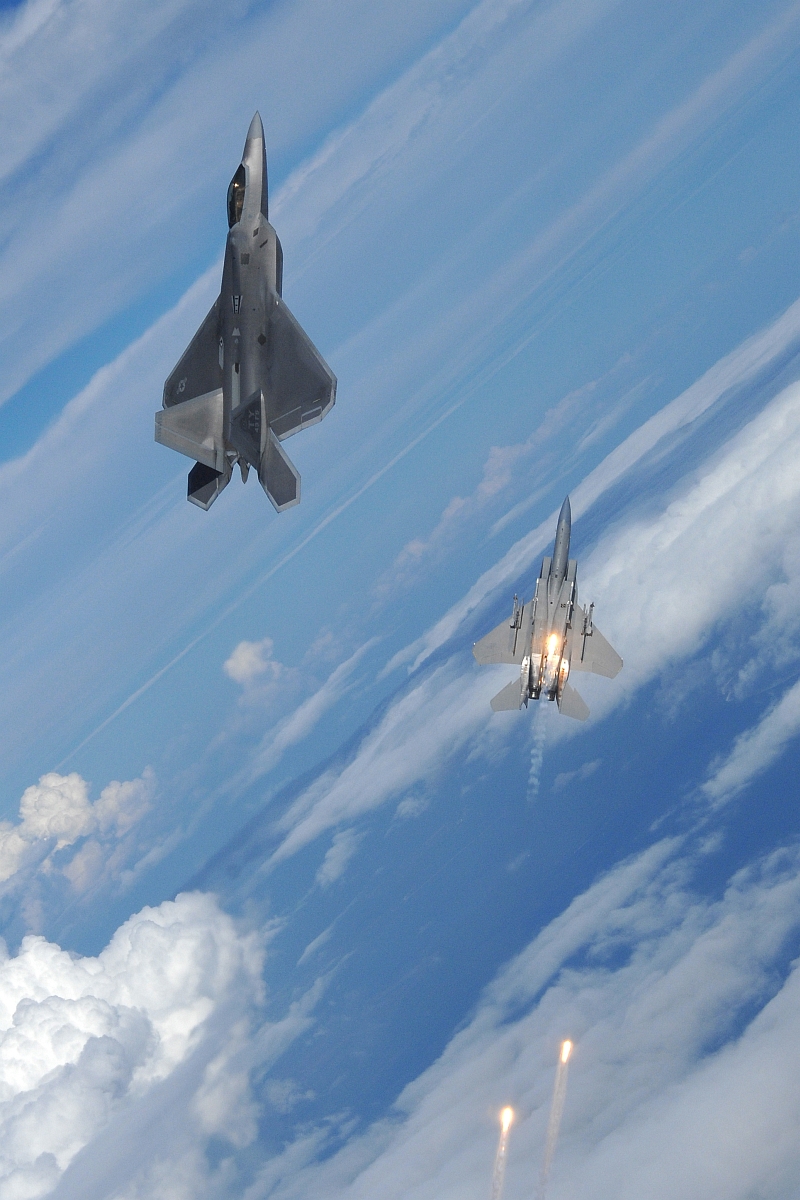 21. A U.S. Air Force F-15 Strike Eagle, Firing Flares, and A U.S. Air Force F-22A Raptor Participate In Air-To-Air Maneuvers, September 22, 2008, State of Florida, USA. Photo Credit: Master Sgt. Scott Reed, United States Air Force; Defense Visual Information (DVI, http://www.DefenseImagery.mil, 080922-F-LP949-009) and United States Air Force (USAF, http://www.af.mil), United States Department of Defense (DoD, http://www.DefenseLink.mil or http://www.dod.gov), Government of the United States of America (USA).