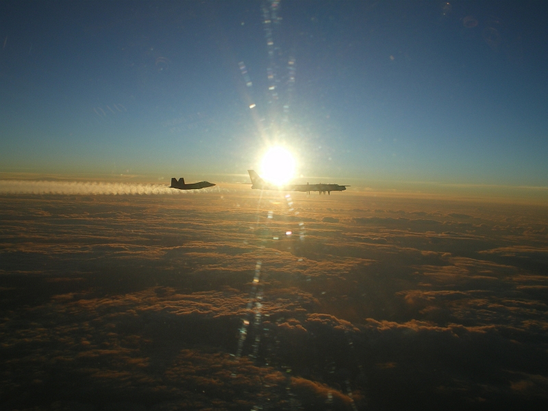 10. Backdropped by the Bright Sun, A U.S. Air Force F-22A Raptor Stealth Fighter Jet Intercepts and Escorts A Russian Tu-95MS Strategic Heavy Bomber, November 22, 2007, Near Alaskan NORAD Region Airspace. Photo Credit: United States Air Force; Pacific Air Forces - Photos (http://www.pacaf.af.mil/photos, 081010-F-1234X-019, "F-22 Raptor intercepts Russian bomber"), United States Department of Defense (DoD, http://www.DefenseLink.mil or http://www.dod.gov), Government of the United States of America (USA). Additional information from the USAF: Two F-22 Raptors from 11th Air Force, 3rd Wing, based at Elmendorf Air Force Base, Alaska intercepted a pair of Russian Tu-95MS strategic bombers on November 22, 2007. Both "Bears" belong to the 326th Heavy Bomber Air Division and are operated from Ukrainka air base. The intercept was a first for the Raptor.