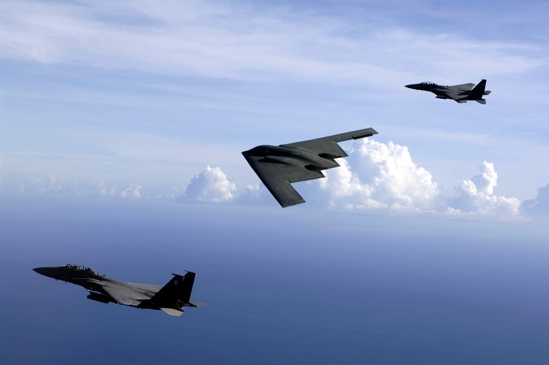 8. Two U.S. Air Force F-15E Strike Eagle Fighter Jets and A U.S. Air Force B-2 Spirit Stealth Bomber Flying In Formation Over the Pacific Ocean, July 5, 2005, Andersen Air Force Base, Territory of Guam, USA. Photo Credit: Technical Sgt. (TSgt) Cecilio M. Ricardo, United States Air Force; Defense Visual Information (DVI, http://www.DefenseImagery.mil, DF-SD-08-19939 or 050705-F-3961R-402) and United States Air Force (USAF, http://www.af.mil), United States Department of Defense (DoD, http://www.DefenseLink.mil or http://www.dod.gov), Government of the United States of America (USA).