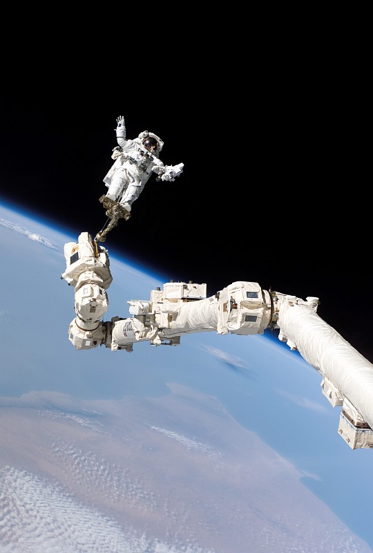 NASA STS-114 Mission, Flight Day 9: The Pitch Black Space Above, a Stunningly Beautiful Planet Earth Below, and Astronaut and STS-114 Mission Specialist Stephen K. Robinson Securely Anchored to a Foot Restraint Attached to the International Space Station. Photo Credit: Return to Flight, STS-114 Mission: Space Shuttle Discovery, Multimedia - Photo Gallery: Flight Day 9 Highlights (http://www.nasa.gov/returntoflight/multimedia/fd9_gallery.html), Photo ID: S114E6642, National Aeronautics and Space Administration (NASA, http://www.nasa.gov), Government of the United States of America.