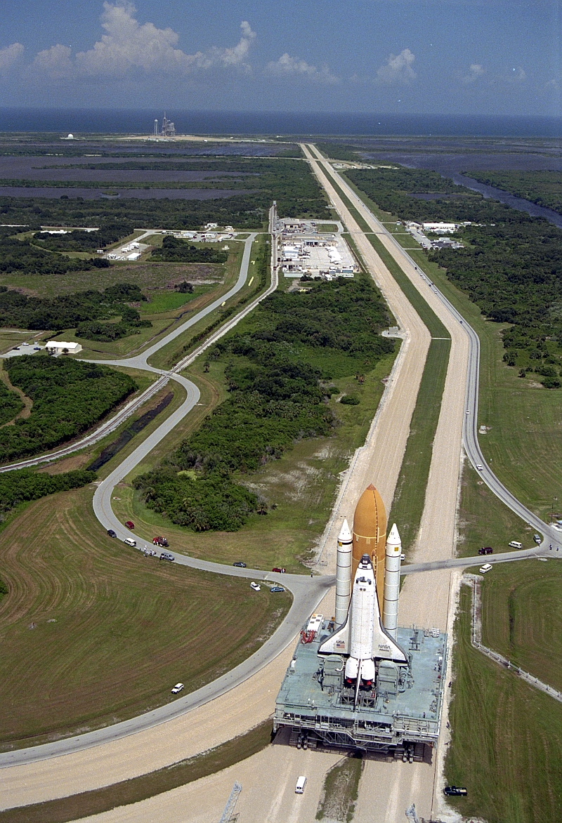 10. Scenic View of the Area Surrounding Space Shuttle Atlantis (STS-79), Atop the Mobile Launcher Platform (MLP) and Crawler-Transporter, As It Slowly Rolls Out to Launch Pad 39A on Merrit Island, August 20, 1996, NASA John F. Kennedy Space Center, State of Florida, USA. Photo Credit: NASA; Rollout of Space Shuttle Atlantis (STS-79) to Launch Pad 39A, GRIN (http://grin.hq.nasa.gov) Database Number: GPN-2000-000967, National Aeronautics and Space Administration (NASA, http://www.nasa.gov), Government of the United States of America.