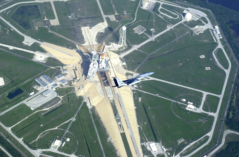 2. Operation Noble Eagle: Aerial View of a Florida Air National Guard F-15C Eagle Fighter Jet, Assigned to the 125th Fighter Wing, Flying a Combat Air Patrol (CAP) Mission Over Cape Kennedy As Space Shuttle Endeavour (STS-108) Sits On Launch Pad 39B, November 29, 2001, NASA John F. Kennedy Space Center, State of Florida, USA. Photo Credit: Tech. Sgt. (TSgt.) Shaun Withers, United States Air Force (USAF, http://www.af.mil); Defense Visual Information Center (DVIC, http://www.DoDMedia.osd.mil, DF-SD-03-17847 and 011129-F-1279W-025) and United States Air Force (USAF, http://www.af.mil), United States Department of Defense (DoD, http://www.DefenseLink.mil or http://www.dod.gov), Government of the United States of America (USA).