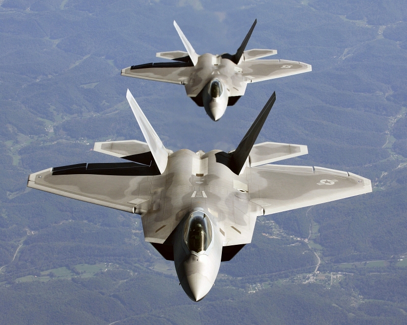 19. Two U.S. Air Force F-22A Raptor Stealth Fighter Jets, In Trailing Formation, Fly To Hill Air Force Base, Utah, For Exercise Combat Hammer, October 15, 2005. Photo Credit: Tech. Sgt. Ben Bloker, United States Air Force; Defense Visual Information (DVI, http://www.DefenseImagery.mil, DF-SD-08-17711 and 051015-F-2295B-043) and United States Air Force (USAF, http://www.af.mil), United States Department of Defense (DoD, http://www.DefenseLink.mil or http://www.dod.gov), Government of the United States of America (USA).