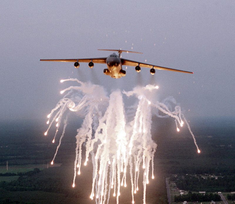 1. Flares and smoke from the flare salvo -- fired by an overland United States Air Force C-141B Starlifter Cargo and Troop Transport, a jet-powered airlifter -- leaves in the sky a bright, dazzling-to-the-eye, white, spectacular formation with glowing "tips" that are very hot. The well-defined vortex on the left is caused by air turbulence created by the flight of the C-141B StarLifter aircraft. The flare countermeasure, a self-defense decoy operation or technique, is used to help protect the aircraft from an attack (or attacks) by deadly heat-seeking missiles. Photo Credit: Senior Airman Greg Davis, Air Force Link - Photos (http://www.af.mil/photos, 021205-O-9999G-017, "Fireworks display"), United States Air Force (USAF, http://www.af.mil), United States Department of Defense (DoD, http://www.DefenseLink.mil or http://www.dod.gov), Government of the United States of America (USA).