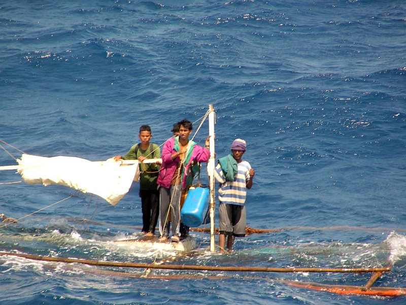 Standing On the Remains of Their Submerged Boat, These Four (4) Young Men (Possibly Fishermen) Wait For the Soon-To-Begin Rescue Operation By a Small Boat From the United States Navy's High Speed Vessel Swift (HSV 2), October 19, 2006 at Subic, Republika ng Pilipinas - Republic of the Philippines. Photo Credit: U.S. Navy, Navy NewsStand - Eye on the Fleet Photo Gallery (http://www.news.navy.mil/view_photos.asp, 061019-N-XXXXN-002), United States Navy (USN, http://www.navy.mil), United States Department of Defense (DoD, http://www.DefenseLink.mil or http://www.dod.gov), Government of the United States of America (USA).