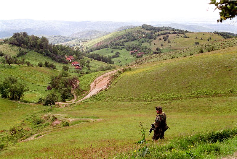 Rolling Hills Covered In Green Meadows and Fields and Trees and Forrests, Dotted Here and There With Homes -- It's a Very Beautiful and Picturesque Scene, June 5, 2001, Mijak, Kosovo, Republika Srbija - Republic of Serbia. Photo Credit: Robert D. Ward, States Department of Defense; DefenseLINK News Photos (http://www.DefenseLink.mil/photos/, 010605-D-9880W-290), United States Department of Defense (DoD, http://www.DefenseLink.mil or http://www.dod.gov), Government of the United States of America (USA).