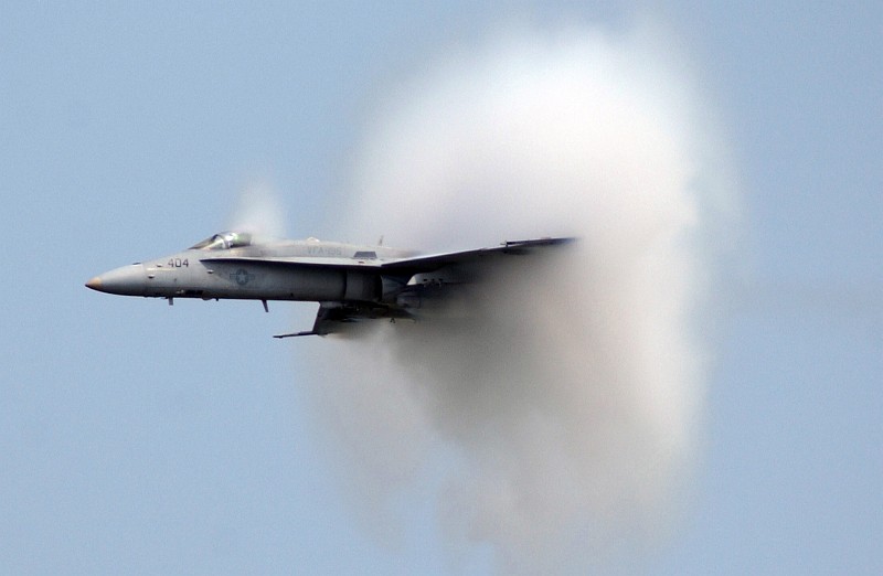 8. A United States Marine Corps F/A-18C Hornet Fighter Jet Assigned to the Strike Fighter Squadron One Nine Five (VFA-195) at Naval Air Station Atsugi (Japan), Freedom Through Friendship Air Show at Osan Air Base, September 10, 2005, Kyonggi-Do Province, Taehan-min'guk - Republic of Korea. Flying at transonic speeds (flying transonically) -- speeds varying near and at the speed of sound (supersonic) -- can generate impressive condensation clouds caused by the Prandtl-Glauert Singularity. For a scientific explanation, see Professor M. S. Cramer's Gallery of Fluid Mechanics, Prandtl-Glauert Singularity at <http://www.GalleryOfFluidMechanics.com/conden/pg_sing.htm>; and Foundations of Fluid Mechanics, Navier-Stokes Equations Potential Flows: Prandtl-Glauert Similarity Laws at <http://www.Navier-Stokes.net/nspfsim.htm>. Photo Credit: Tech. Sgt. Raheem Moore, United States Air Force (USAF, http://www.af.mil); Defense Visual Information Center (DVIC, http://www.DoDMedia.osd.mil, DFSD0602979 and 050910F4707M142) and United States Marine Corps (USMC, http://www.usmc.mil), United States Department of Defense (DoD, http://www.DefenseLink.mil or http://www.dod.gov), Government of the United States of America (USA).