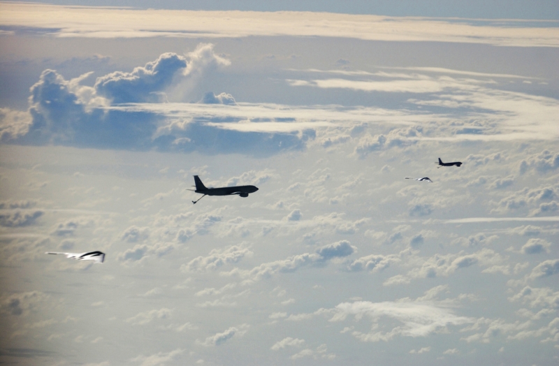 Operation Iraqi Freedom: High Above the Clouds, Two U.S. Air Force KC-135 Stratotankers (From the 28th Expeditionary Air Refueling Squadron) Prepare to Refuel Two U.S. Air Force B-2 Spirit Stealth Bombers (Forward Deployed With the 40th Air Expeditionary Wing), March 21, 2003. Photo Credit: MSgt. Timothy Lancaster, United States Air Force; Defense Visual Information (DVI, http://www.DefenseImagery.mil, 030321-F-DC852-003) and United States Air Force (USAF, http://www.af.mil), United States Department of Defense (DoD, http://www.DefenseLink.mil or http://www.dod.gov), Government of the United States of America (USA).