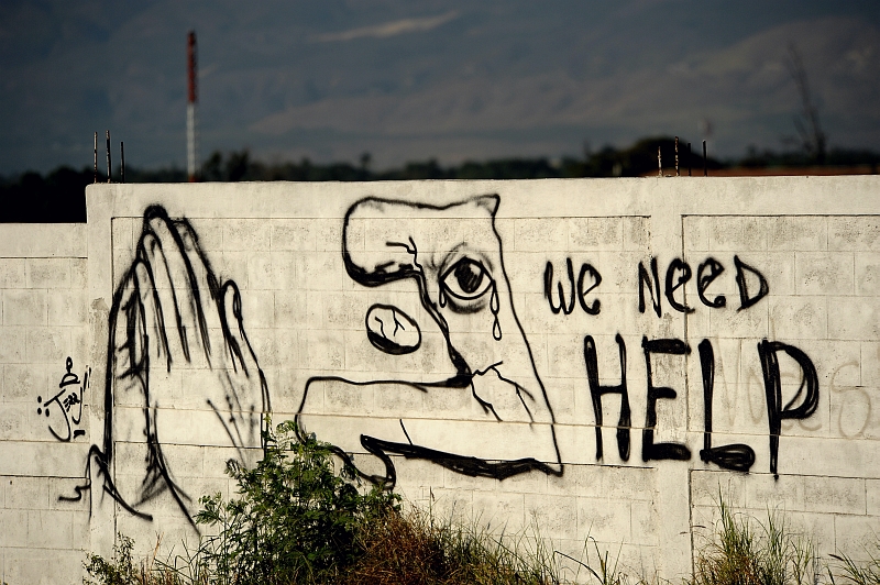 45. Graffiti Painted On the Wall: 'We Need HELP', January 22, 2010, Port-au-Prince, Republique d'Haiti (Repiblik d' Ayiti) - Republic of Haiti.  Photo Credit: Master Sgt. Jeremy Lock, United States Air Force; Defense Visual Information (DVI, http://www.DefenseImagery.mil, 100122-F-1644L-205) and United States Air Force (USAF, http://www.af.mil), United States Department of Defense (DoD, http://www.DefenseLink.mil or http://www.dod.gov), Government of the United States of America (USA).