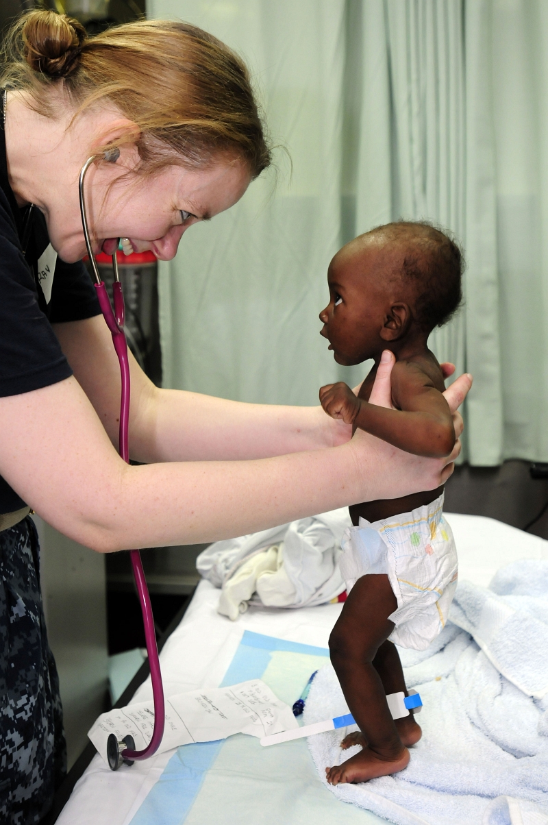 40. United States Navy Lt. Dr. Jerri Gram Holds Up An Infant Girl -- A Victim and Survivor of the 7.0-Magnitude Earthquake -- and Shares A Smile With Her During A Medical Examination Aboard the U.S. Navy Military Sealift Command Hospital Ship USNS Comfort (T-AH 20), January 21, 2010, Port-au-Prince, Republique d'Haiti (Repiblik d' Ayiti) - Republic of Haiti. Photo Credit: Mass Communication Specialist 2nd Class Edwardo Proano, United States Navy; Defense Visual Information (DVI, http://www.DefenseImagery.mil, 100121-N-4378P-116) and United States Navy (USN, http://www.navy.mil), United States Department of Defense (DoD, http://www.DefenseLink.mil or http://www.dod.gov), Government of the United States of America (USA).