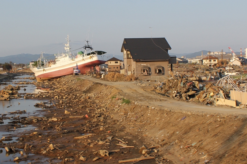 4. Grounded By the Tsunami, A Japanese Ship (Vessel) Sits Next to A House In Iwakuni, May 24, 2011, Nippon-koku (Nihon-koku) - Japan. Photo Credit: Lance Cpl. Kenneth Trotter, United States Marine Corps; Defense Visual Information (DVI, http://www.DefenseImagery.mil, 110524-M-VI633-799) and United States Marine Corps (USMC, http://www.marines.mil), United States Department of Defense (DoD, http://www.DefenseLink.mil or http://www.dod.gov), Government of the United States of America (USA).