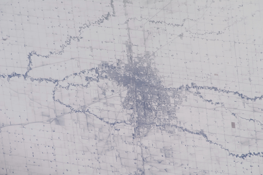 4. Land, Rivers, and A City, February 18, 2014 at 21:31:02 GMT, As Seen From the International Space Station (Expedition 38) While Orbiting Above State of Minnesota, USA, Latitude (LAT): 45.1, Longitude (LON): -93.3, Altitude (ALT): 221 Nautical Miles, Sun Azimuth (AZI): 229 degrees, Sun Elevation Angle (ELEV): 20 degrees. Photo Credit: NASA; ISS038-E-51545, International Space Station (Expedition 38); Image Science and Analysis Laboratory, NASA-Johnson Space Center. "The Gateway to Astronaut Photography of Earth." <http://eol.jsc.nasa.gov/scripts/sseop/photo.pl?mission=ISS038&roll=E&frame=51545>; National Aeronautics and Space Administration (NASA, http://www.nasa.gov), Government of the United States of America (USA).